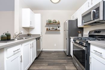 A kitchen with white cabinets and black appliances.